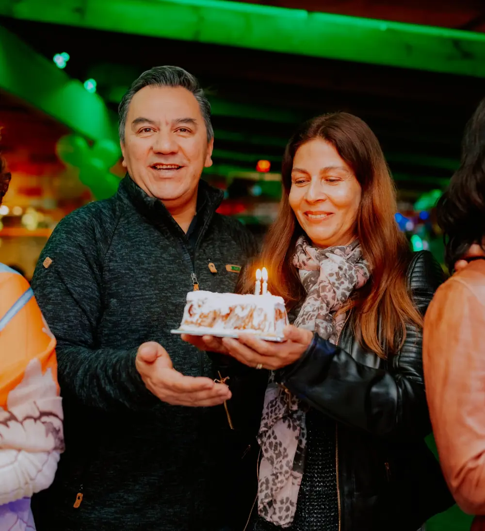 Pareja celebrando un cumpleaños con su torta en Verde Mostaza
